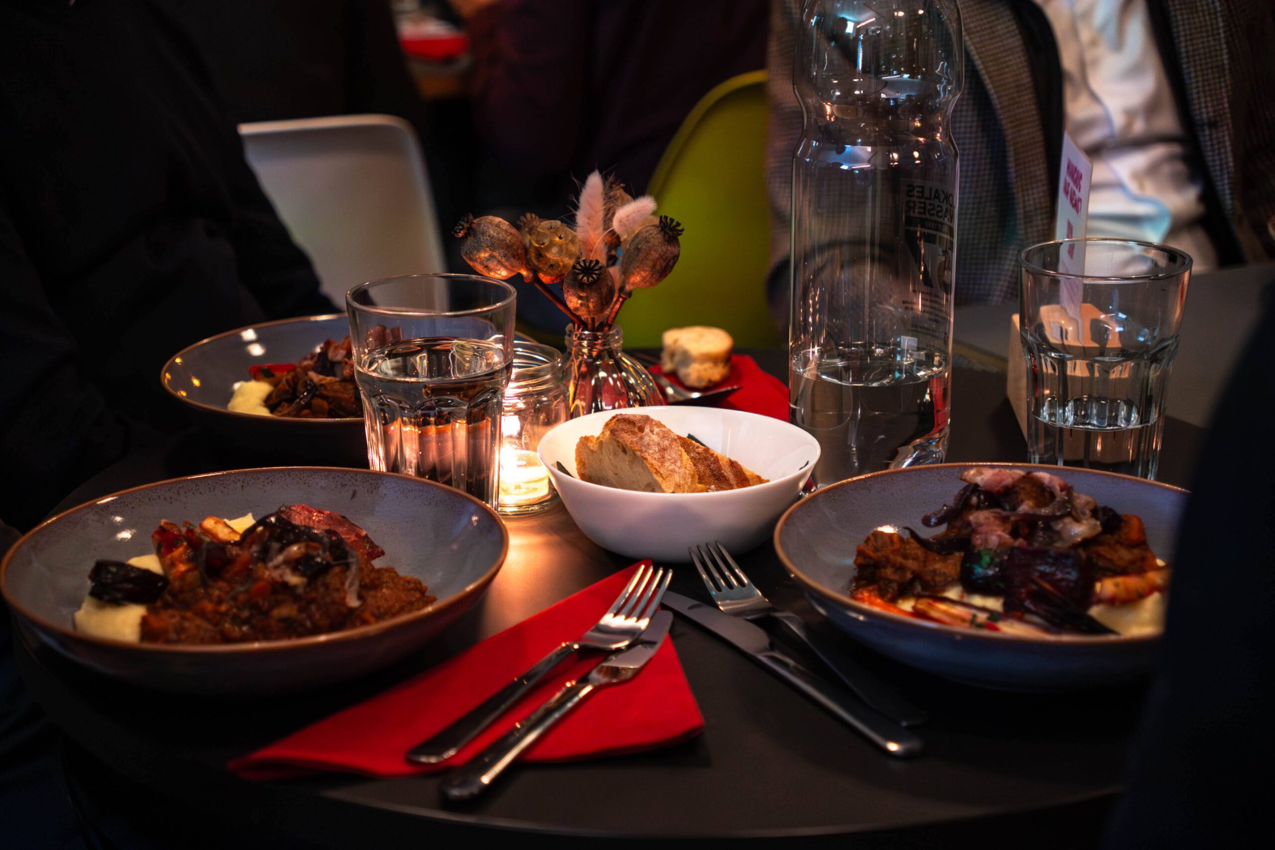 Stimmungsvoller Restauranttisch mit Gourmetgerichten und Kerzenlicht